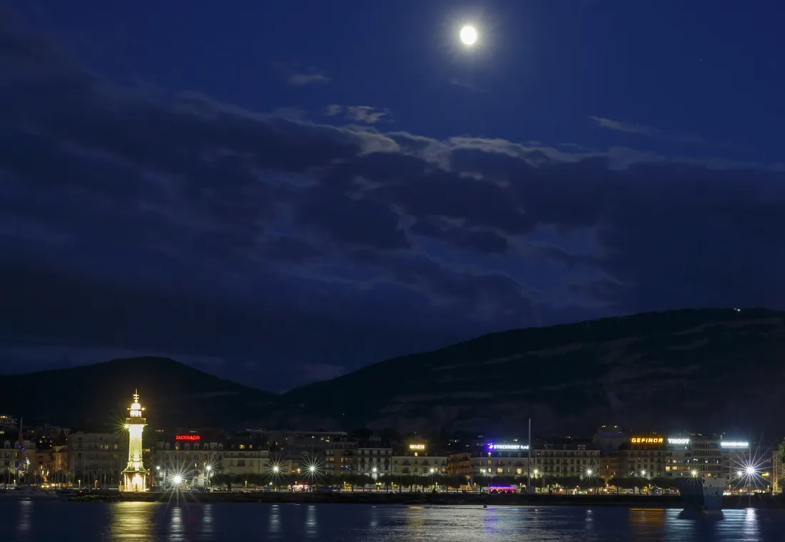 Lake Geneva at night, with the Bains des Paquis lighthouse and the city lights